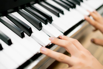 close up hands playing different chords on piano keys f