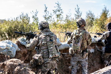 special forces, soldier assault rifle with silencer, optical sight. behind cover waiting in ambush