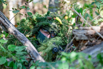 special forces, soldier assault rifle with silencer, optical sight. behind cover waiting in ambush