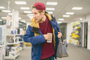 criminal thief stealing cell phone in the shop looking sideways f