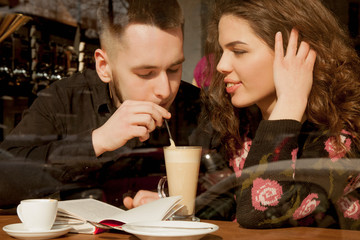 Holidays, winter, christmas, hot drinks and people concept - happy couple of young people drinking coffee from disposable paper cups