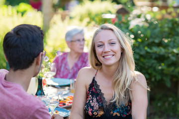 Family picnic. Focus to a beautiful young woman looks at camera