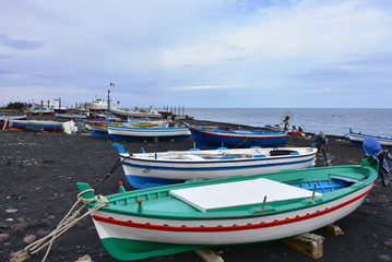 Naklejka na ściany i meble Stromboli island ,black sand and small boats 