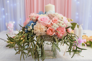 Delicate wedding bouquet with roses is in a vase on the table