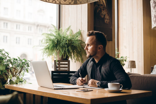 Adult serious man has business conversations using on-line mobile application. Developer innovational business web applications in the internet. Stylish guy. Business portrait. Cloud technologies.