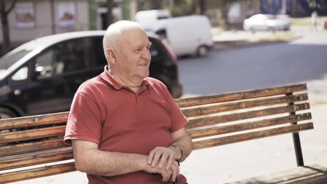 An senior has a rest alone on the bench in a sunny day.