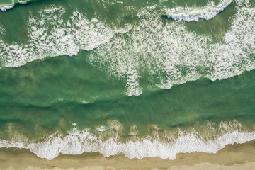 Aerial view of turquoise sea waves and beach