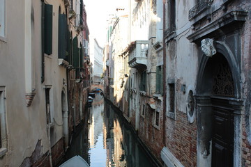 Fototapeta na wymiar The canal in Venice. Ancient buildings, bridges, boats, reflections in the water