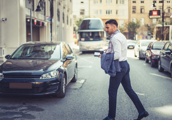 Handsome urban businessman walking and looking serious