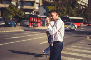 Handsome businessman walking on the pedestrian crossing