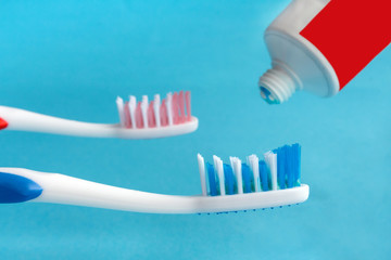 concept of dental health. Two toothbrush red and blue and toothpaste on a blue background. Design, health care, healthy hygiene