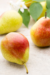 Fresh pears with leaves in a on wooden background.