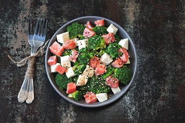 Healthy salad with broccoli, white cheese and salmon fillet. The concept of dietary nutrition. Tasty and healthy lunch dish for two.