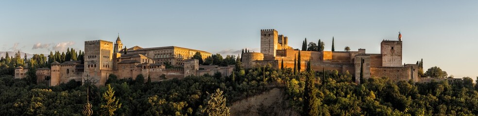 Fototapeta na wymiar Panorama photograph of the Alhambra Palace of Granada Spain at sunset. Vast medieval fortress castle complex overlooking Granada, built by the Moorish Empire. 