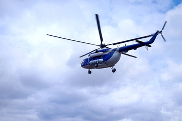 Naklejka na ściany i meble White blue helicopter on the sky background.