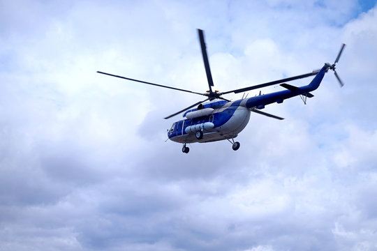 White blue helicopter on the sky background.