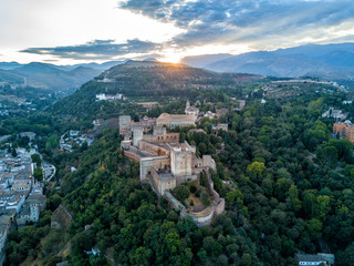 Aerial drone photo of The Alhambra Palace of Granada Spain at sunrise.  Vast castle fortress complex overlooking Granada, built by the Moorish Empire.  