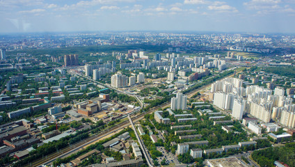 Top view of big city in the summer. Urban panorama of cityscape and blue sky, groups of buildings.