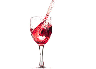 Red wine falls into a glass and creates splash and splashes on a white background.