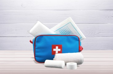 First aid kit  with medical supplies on light background