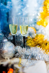 couple.  glasses with sparkling white wine on the background of a New Year's shiny decor