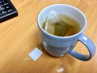 A cup of green tea powder in bag - The way to make tea in the office requires urgency.