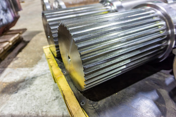 Splined shaft lies on the rack after machining in oil, and is ready for further use in production.