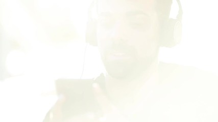 Millenial young man using his smartphone for listening music with headphones