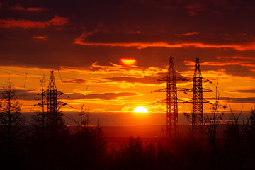 Silhouette of high voltage posts at sunset. Norilsk.