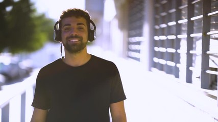 Millenial young man using his smartphone for listening music with headphones