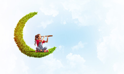 Concept of careless happy childhood with girl on green moon