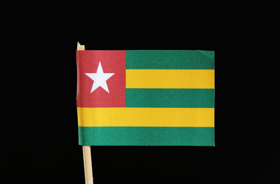 A official and original flag of Togo on toothpick on black background. It has five bands of green alternating with yellow and red field with star