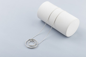 Minimalist geometric silver necklace on gray background