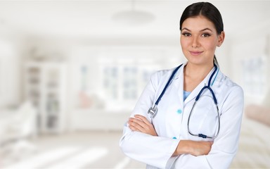 Attractive young female doctor with blurred hospital