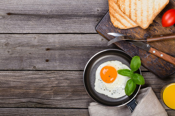 Fried egg with basil on pan