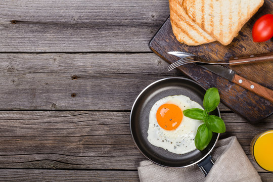 Fried egg with basil on pan