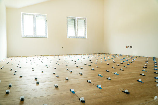 Tile leveling markers in a large empty room during home renovation project