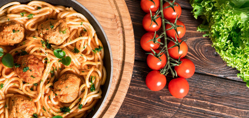 spaghetti with meat and tomatoes on wooden background