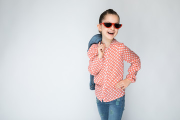 The girl on the grey background keeps behind dzhinsovki.