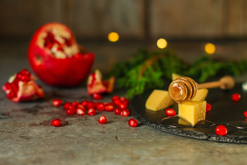 pomegranate grain, cheese and honey - appetizer on a slate plate on a wooden background. top view.