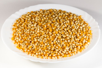White plate with unpopped corn (popcorn kernel's)