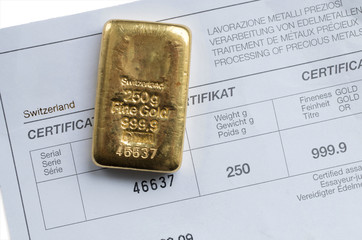 Cast gold bar weighing 250 grams on a background of a certificate.