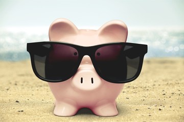 Summer piggy bank with sunglasses on the