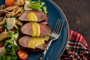 Salad with warm beef with oyster mushrooms, tomatoes and greens. Top view