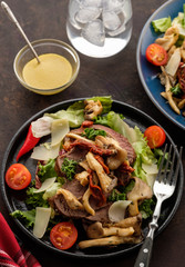 Salad with warm beef with oyster mushrooms, tomatoes and greens. Top view