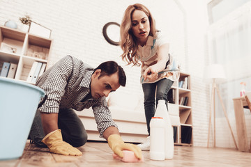 Woman Control Man Cleaning Floor in Apartment.