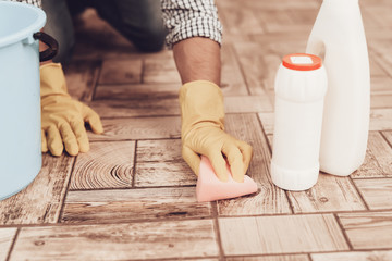 Man in Rubber Gloves with Washcloth Cleaning Floor