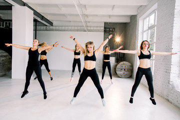 Naklejka premium Fitnes and Stretching Conceots and Ideas. Six Happy Caucasian Female Athletes in Good Fit Having Stretching Exercises in Gym.