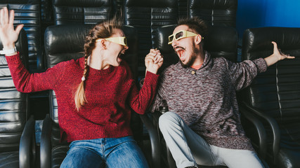 guy and girl 3d glasses are very worried while watching a movie in a cinema