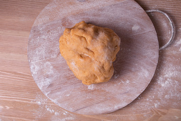 Dough for pasta on a wooden board with flour